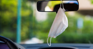 mask hanging from rear-view mirror